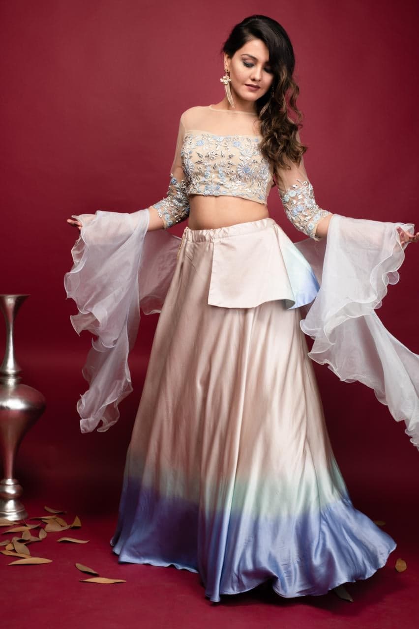 Peach-to-blue ombre lehenga in twirl — fitted nude blouse with silver embroidery and organza ruffle sleeves, photographed in studio.