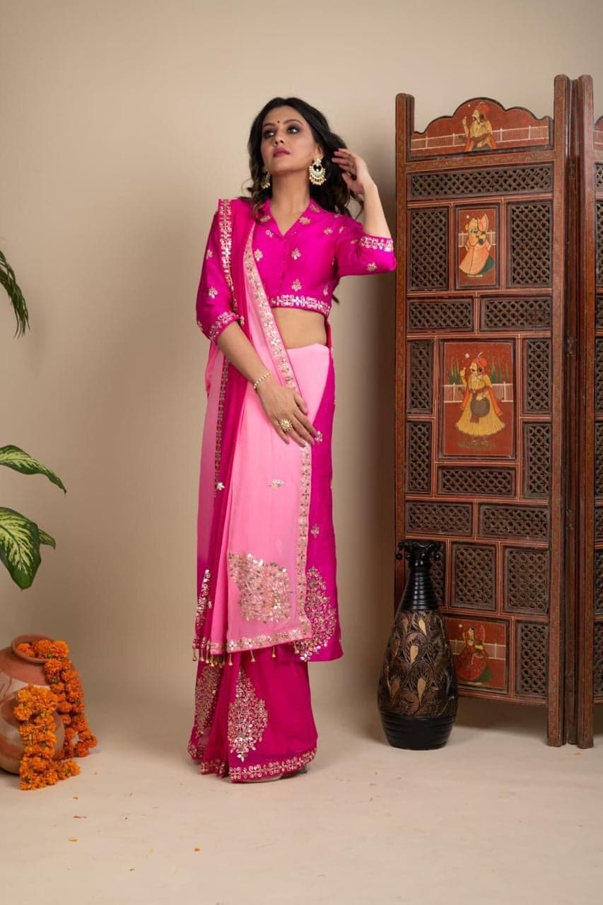 Fuchsia pink saree close detail — gold gota patti embroidery at the palla and embroidered borders, hand-painted screen behind.