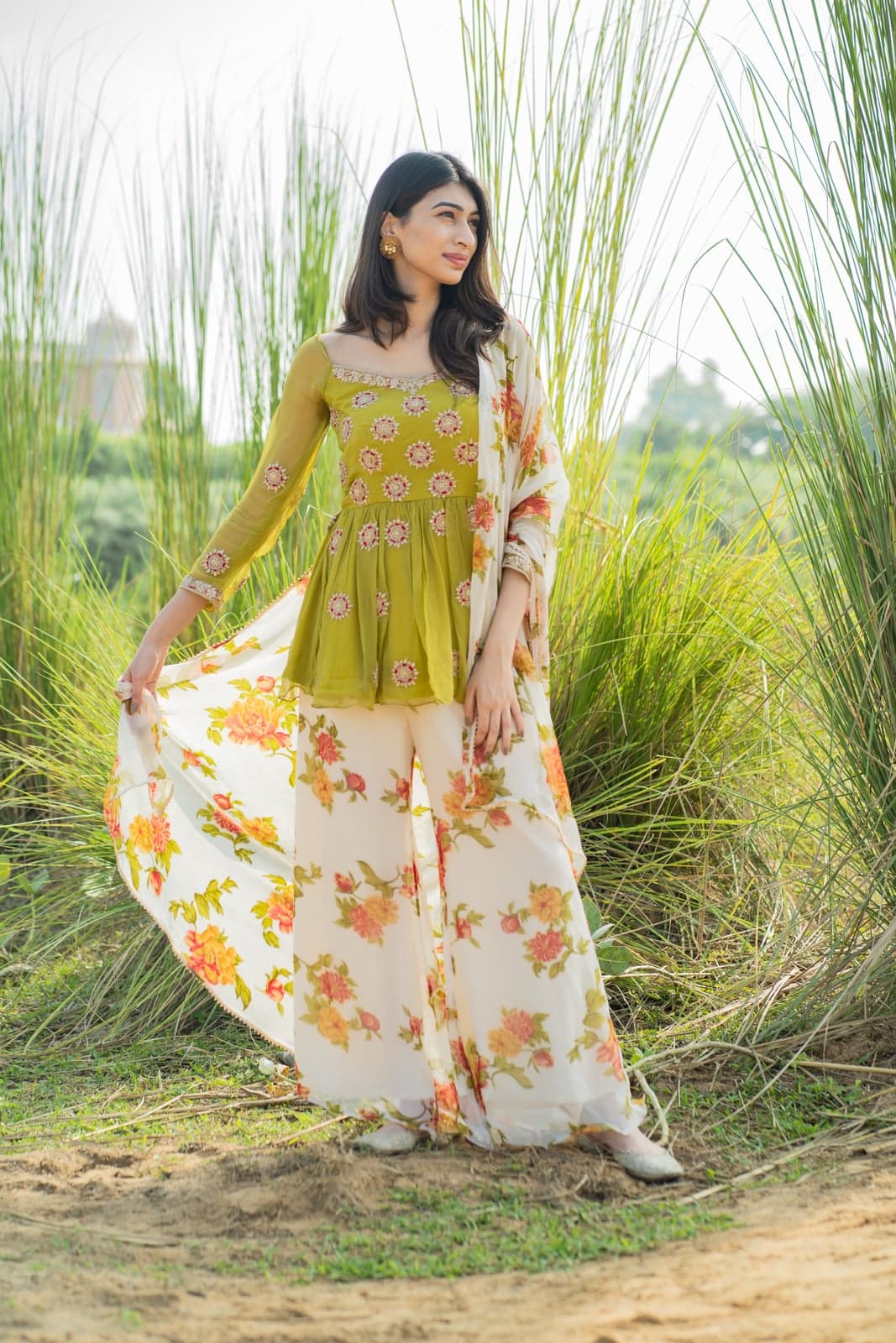Lime green peplum kurta with bead-floral motifs over white floral printed wide-leg pants and dupatta — full-length portrait in pampas grass.