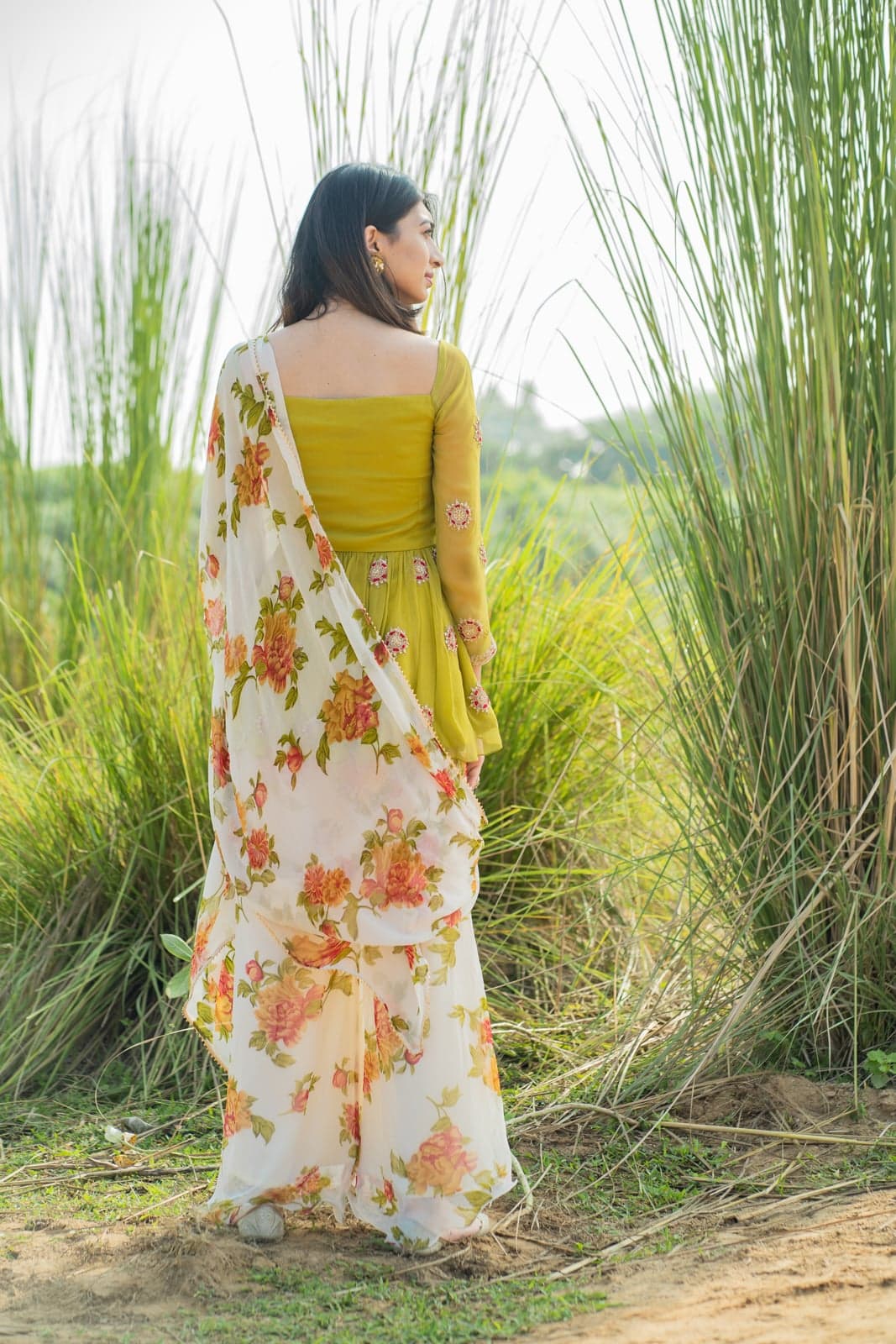 Lime green peplum kurta — back view of the bodice with the floral-printed dupatta trailing across the pampas grass.