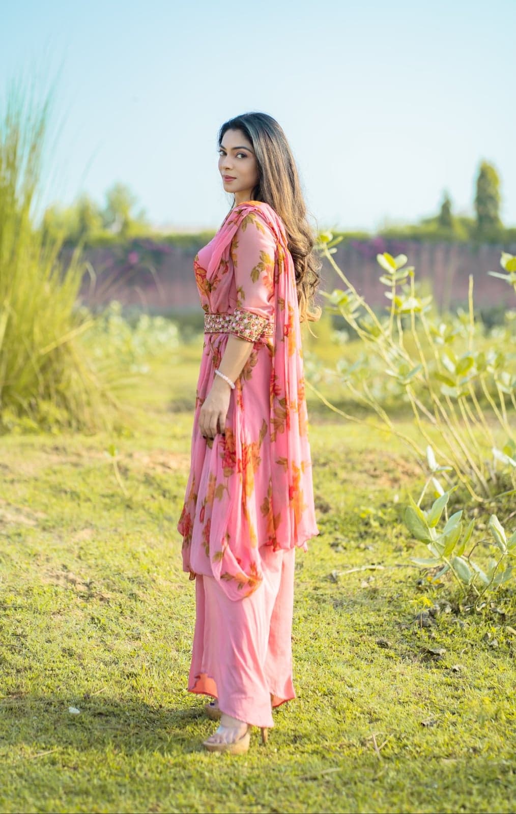 Pink chiffon kurta — side-profile portrait with the rose-print dupatta and embellished belt in focus.