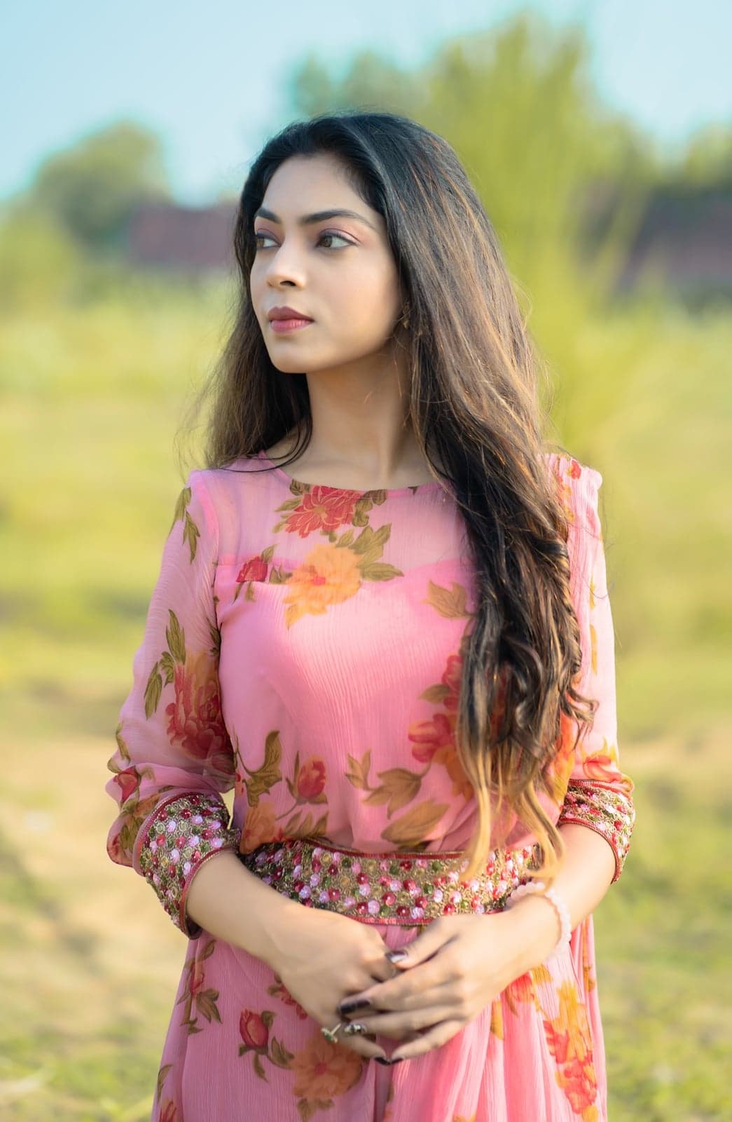 Close portrait of the pink kurta — orange-and-pink rose-print sleeve detail, embellished cuff in focus.