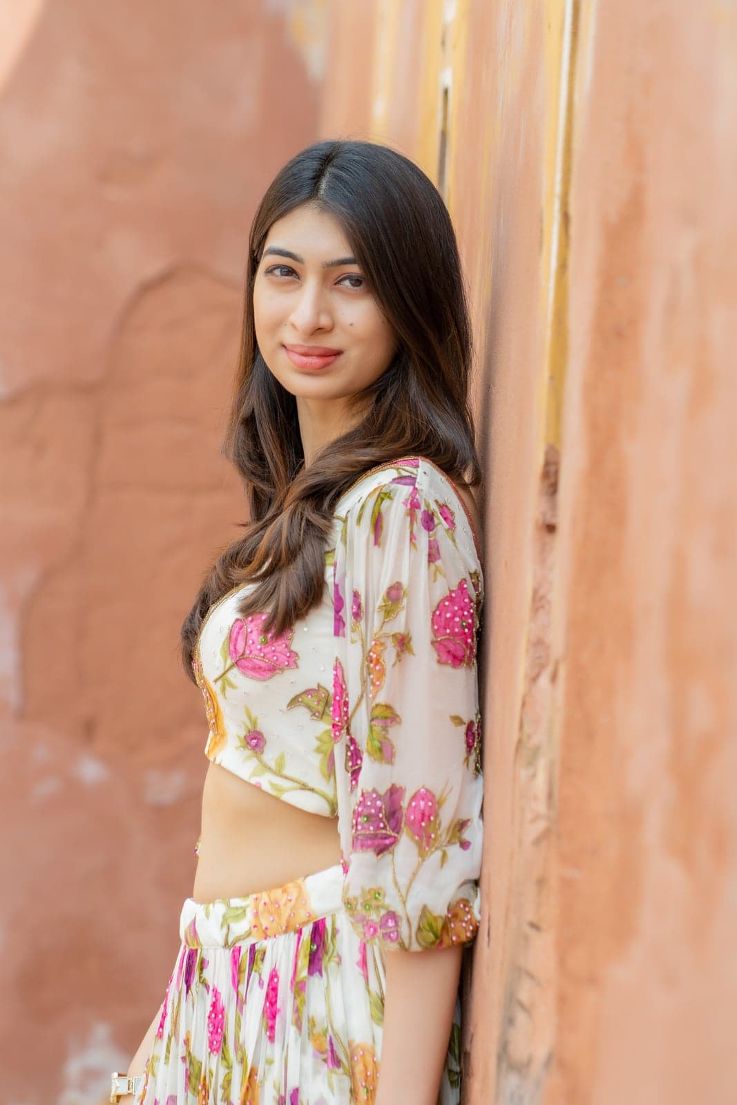 Ivory and pink rose-print maxi — closer outdoor portrait with embellished neckline and balloon sleeves.