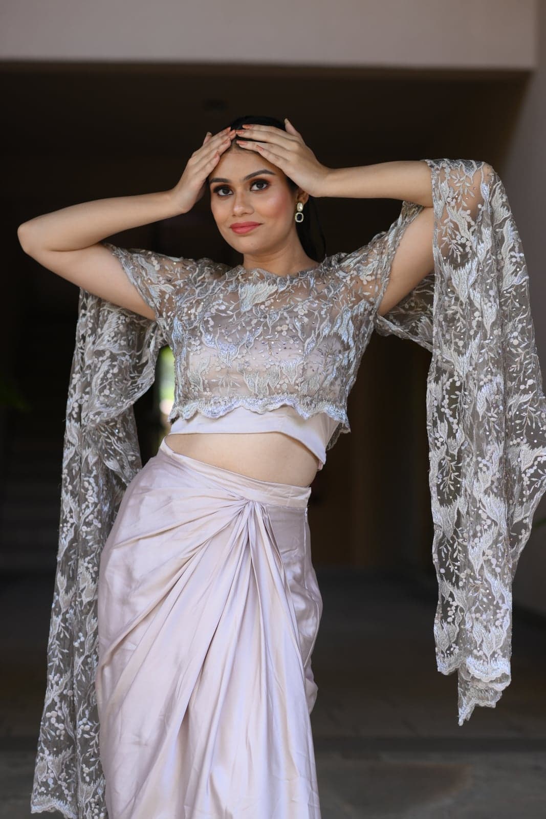 Black strapless feathered-bodice gown with a thigh-high split satin skirt — sandstone wall portrait, soft daylight.