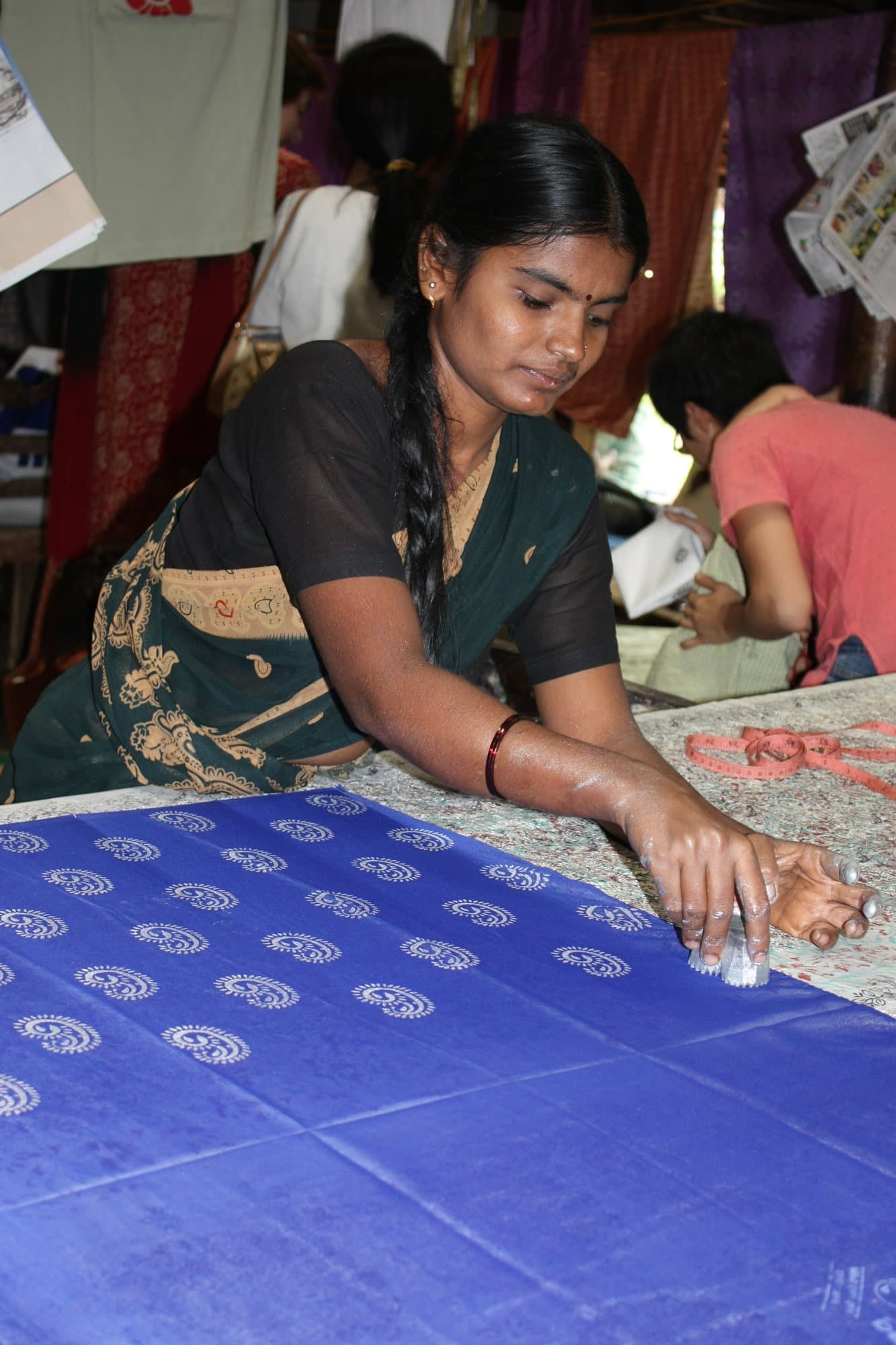A block-printer at work in Sanganer — wooden stamps, indigo, and madder