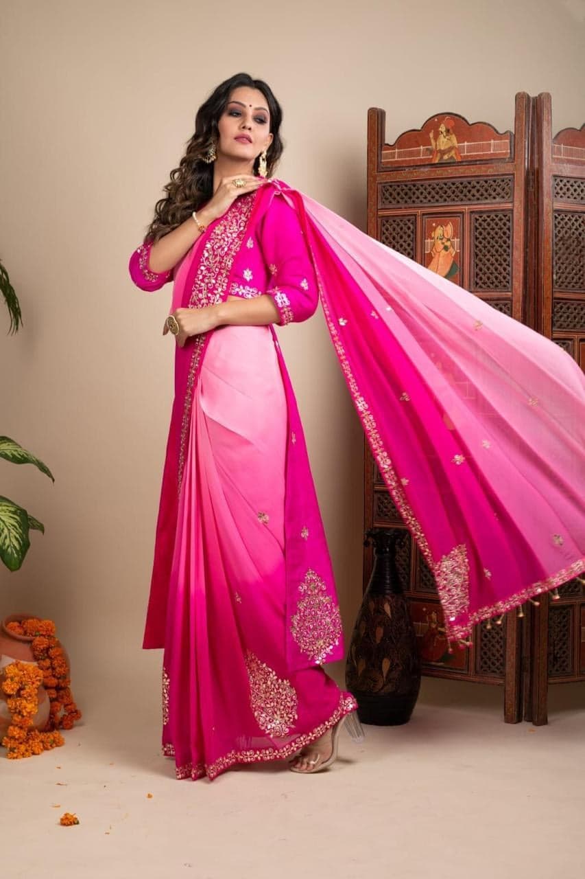 Fuchsia pink saree — full-length study beside a Rajasthani jali screen, gold gota patti motifs along the palla.