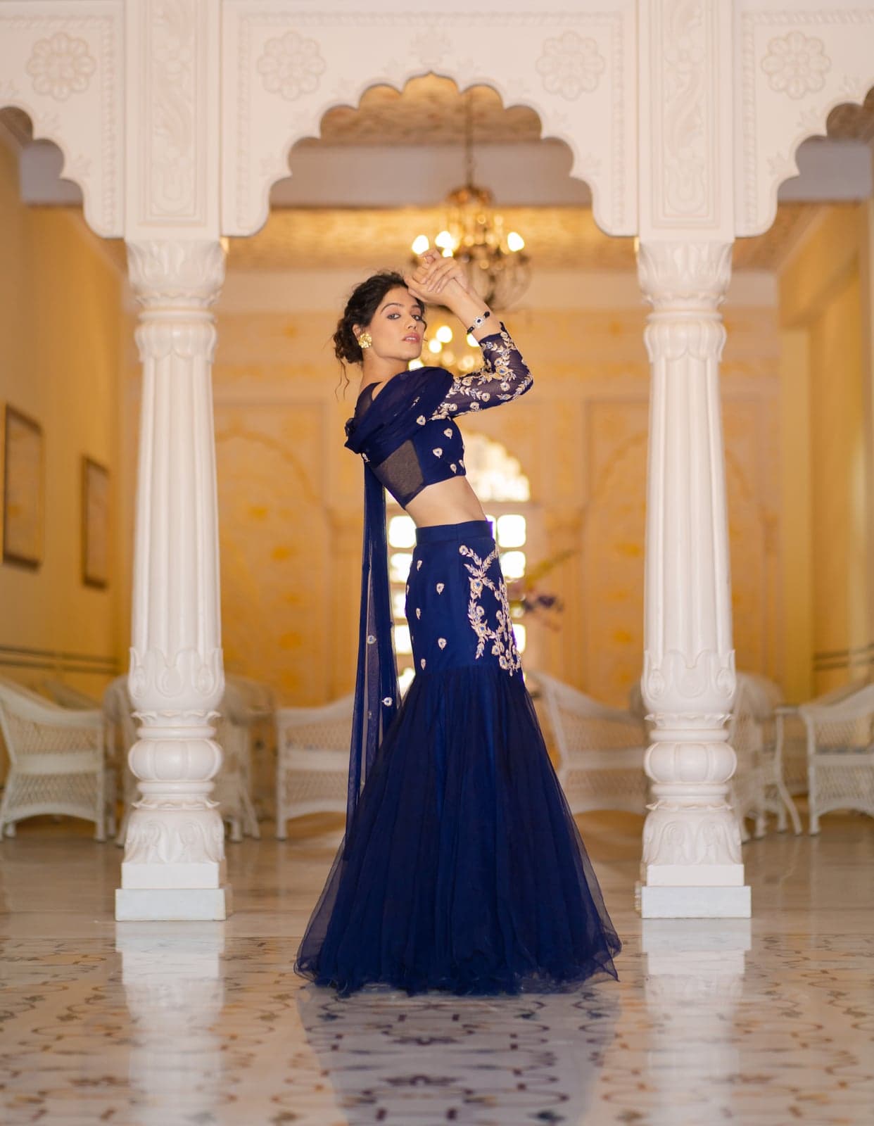 Sapphire blue mermaid lehenga — back-twirl as the hem opens into tulle ruffles beneath the palace chandelier.